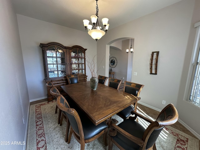 4116 E Sierra Sunset Trl, Cave Creek, AZ 85331 - dining room with arched walkways, a healthy amount of sunlight, a notable chandelier, and baseboards