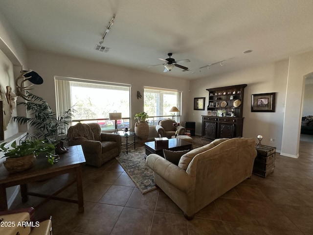 4116 E Sierra Sunset Trl, Cave Creek, AZ 85331 - living area featuring ceiling fan, dark tile patterned floors, visible vents, baseboards, and rail lighting