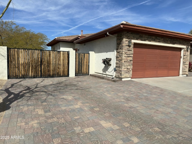 4116 E Sierra Sunset Trl, Cave Creek, AZ 85331 - view of home's exterior with a garage, stone siding, decorative driveway, and stucco siding