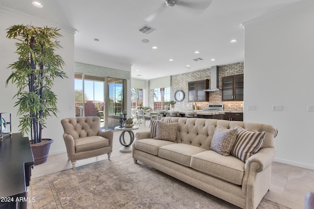 living room featuring crown molding, ceiling fan, and light tile patterned flooring