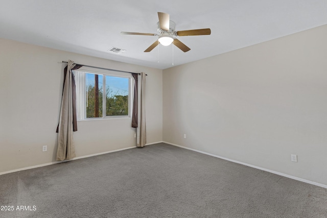 carpeted spare room with visible vents, baseboards, and ceiling fan