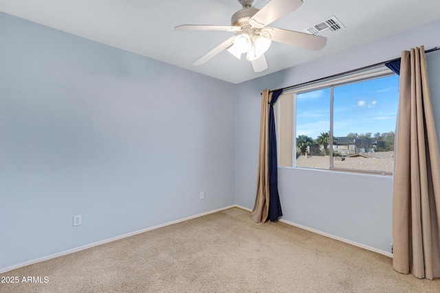 carpeted spare room featuring visible vents, ceiling fan, and baseboards