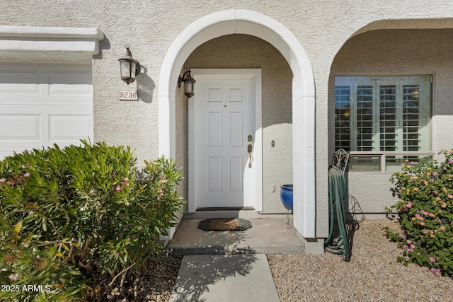 property entrance featuring stucco siding and an attached garage