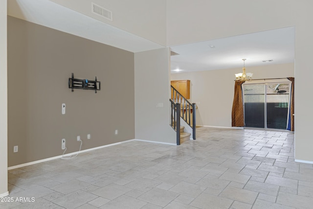 empty room featuring baseboards, visible vents, stairs, stone finish floor, and a chandelier