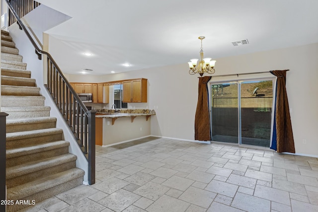 kitchen with baseboards, visible vents, an inviting chandelier, pendant lighting, and stainless steel microwave