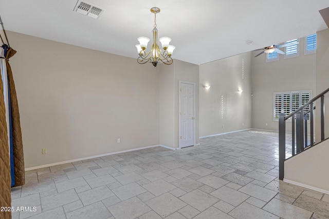 unfurnished room featuring visible vents, baseboards, stairs, stone tile floors, and ceiling fan with notable chandelier