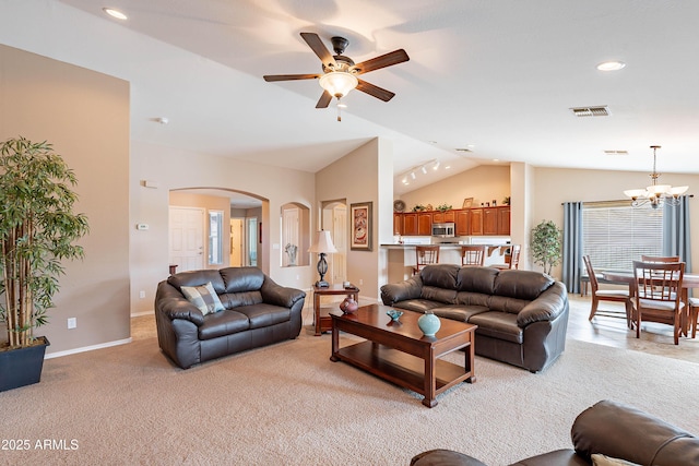 living room featuring ceiling fan with notable chandelier, light colored carpet, and lofted ceiling