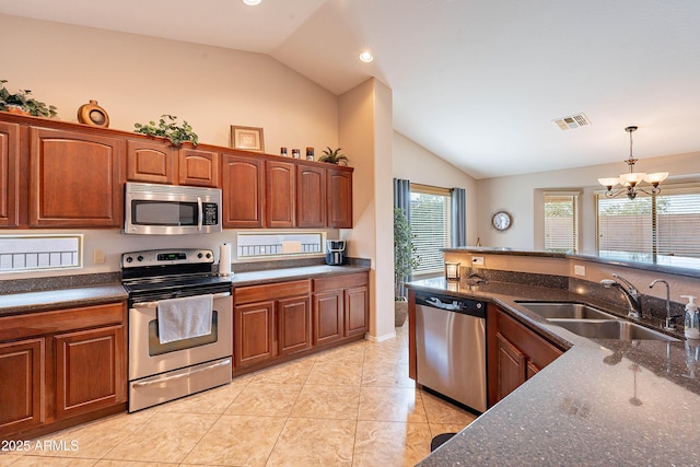 kitchen featuring pendant lighting, appliances with stainless steel finishes, sink, light tile patterned floors, and lofted ceiling