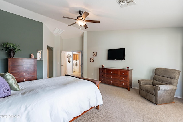 bedroom with ceiling fan, vaulted ceiling, light carpet, and washing machine and clothes dryer