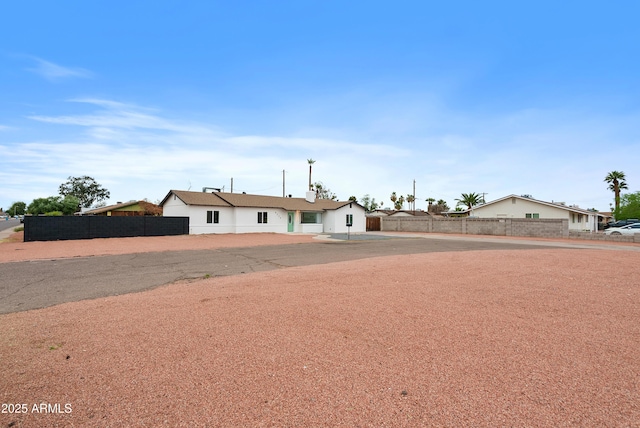 ranch-style home featuring fence