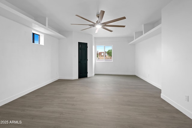 unfurnished room with a ceiling fan, wood finished floors, and baseboards