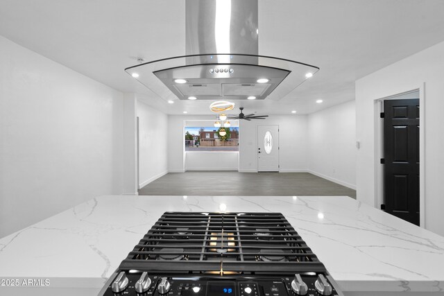 kitchen featuring recessed lighting, wood finished floors, open floor plan, and stone counters