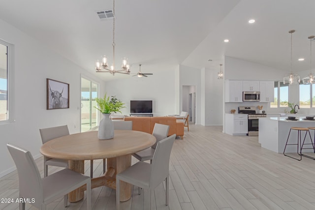 dining area with ceiling fan, light wood-type flooring, plenty of natural light, and lofted ceiling