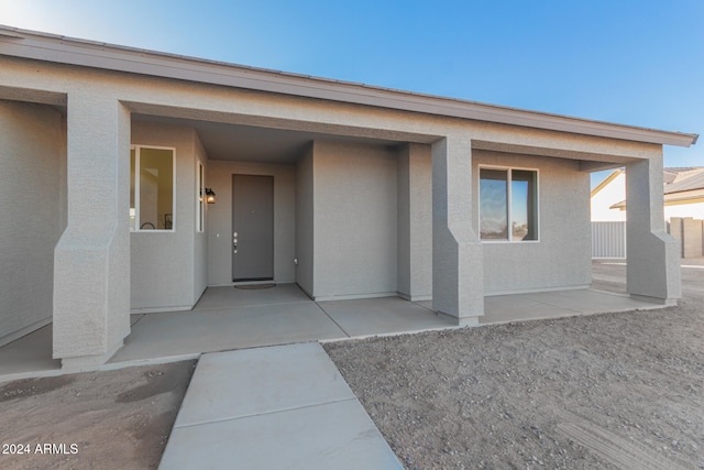 view of exterior entry with a patio area