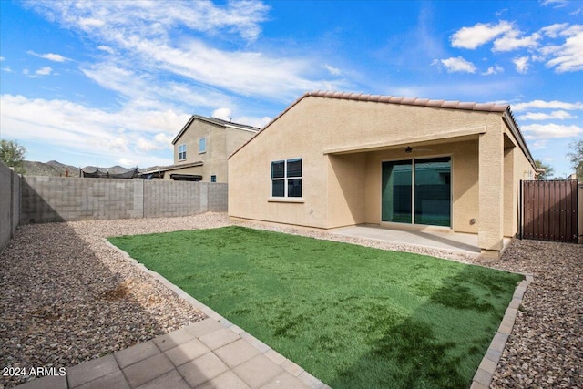 rear view of property featuring a patio and a lawn