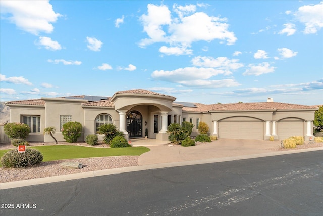 mediterranean / spanish-style home with a garage, a front yard, and solar panels