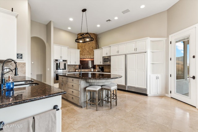 kitchen featuring sink, hanging light fixtures, white cabinets, and appliances with stainless steel finishes