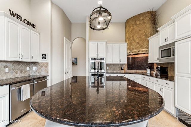 kitchen with stainless steel appliances, white cabinetry, and a kitchen island