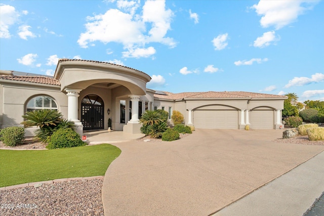 mediterranean / spanish home featuring a garage and a front lawn