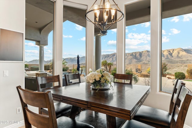 dining room with decorative columns, a mountain view, and a notable chandelier