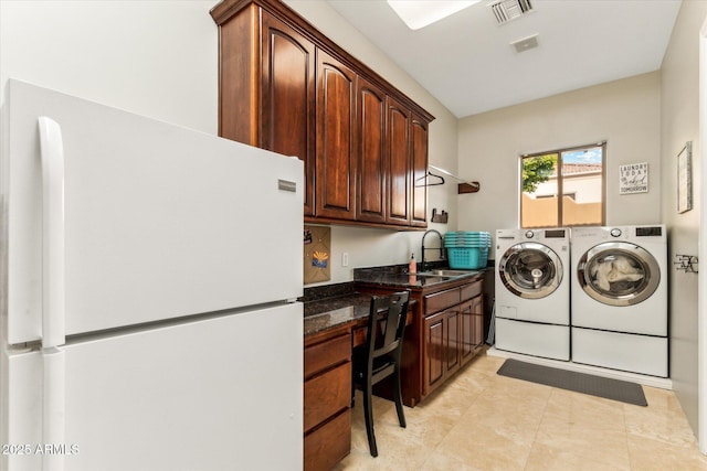 laundry room with cabinets, independent washer and dryer, and sink