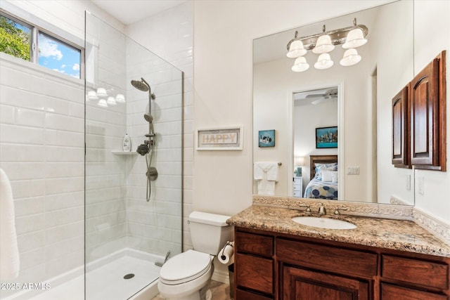 bathroom with vanity, a tile shower, and toilet