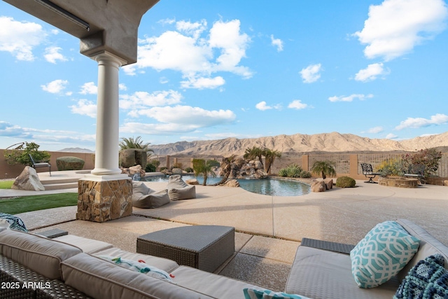 view of patio / terrace featuring a fenced in pool, an outdoor living space, and a mountain view