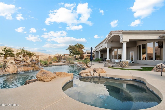 view of pool featuring a hot tub, pool water feature, and a patio area