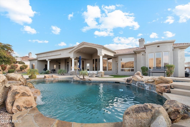 view of pool with a patio and pool water feature