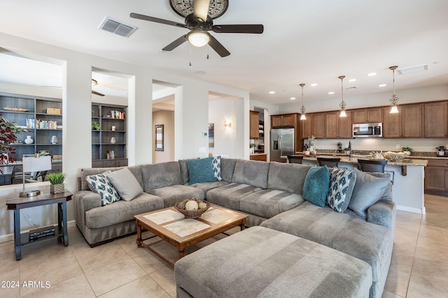 tiled living room with ceiling fan and built in features