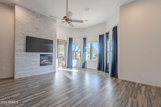 7845 E Dynamite Blvd, Scottsdale, AZ 85266 - unfurnished living room with a fireplace, a ceiling fan, wood finished floors, and a high ceiling