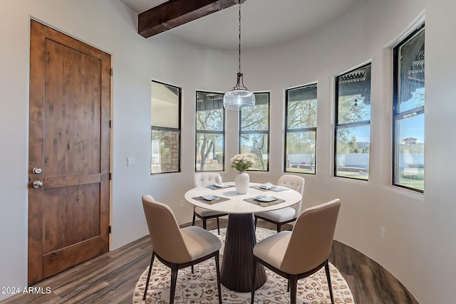 dining area with beam ceiling and dark hardwood / wood-style flooring