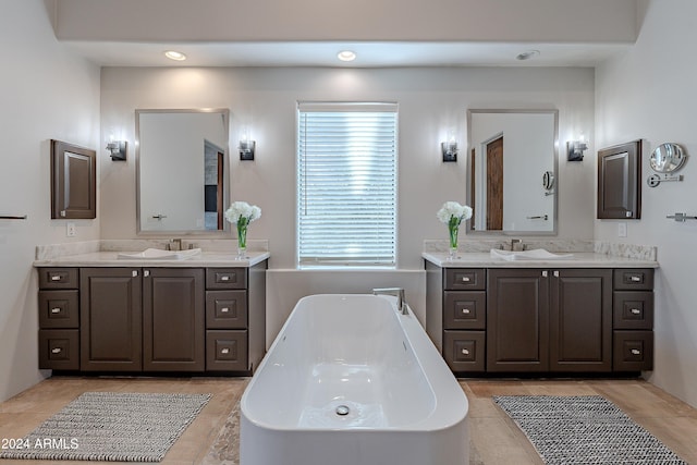 bathroom featuring vanity, tile patterned floors, and a tub