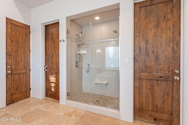 bathroom featuring tile patterned floors and a shower with shower door