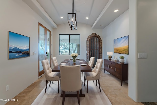 tiled dining room featuring vaulted ceiling