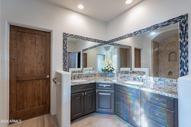 bathroom with tile patterned floors, vanity, and tiled shower