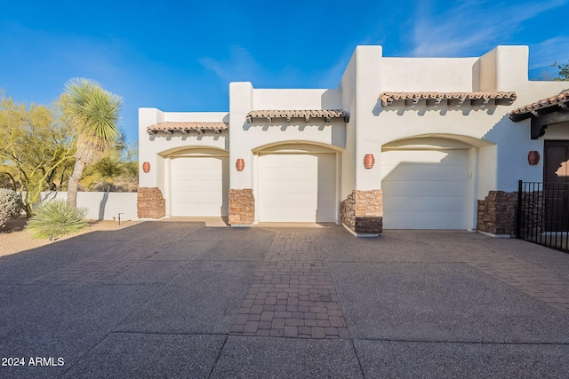 7845 E Dynamite Blvd, Scottsdale, AZ 85266 - view of front of home featuring decorative driveway, stucco siding, an attached garage, stone siding, and a tile roof