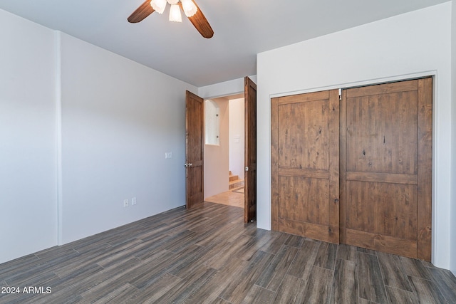 unfurnished bedroom with ceiling fan, a closet, and dark wood-type flooring