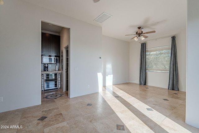 unfurnished room with ceiling fan and wine cooler