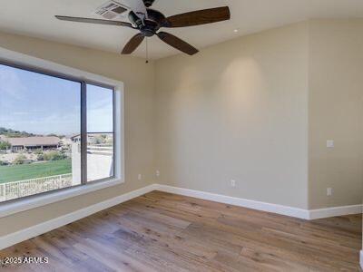 3634 N Desert Oasis, Mesa, AZ 85207 - empty room featuring healthy amount of natural light, baseboards, wood finished floors, and ceiling fan