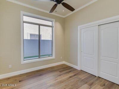 3634 N Desert Oasis, Mesa, AZ 85207 - unfurnished bedroom featuring ornamental molding, wood finished floors, baseboards, a closet, and a ceiling fan