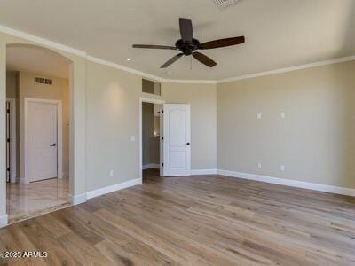 3634 N Desert Oasis, Mesa, AZ 85207 - empty room with arched walkways, a ceiling fan, wood finished floors, ornamental molding, and baseboards