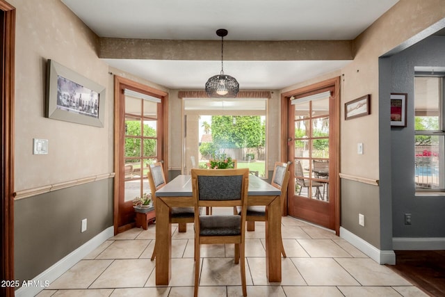 dining area featuring light tile patterned flooring and baseboards
