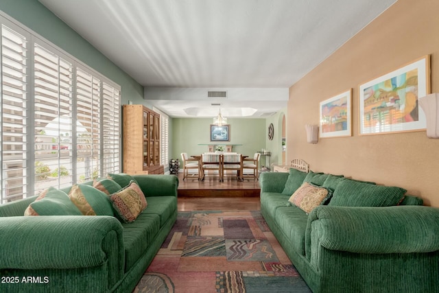 living area with wood finished floors, visible vents, and a wealth of natural light