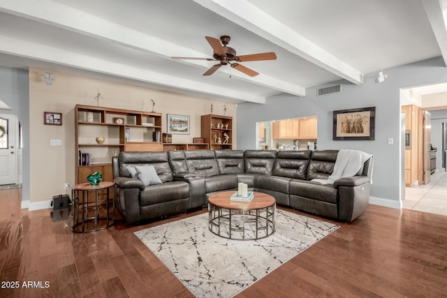 living room with visible vents, beamed ceiling, ceiling fan, and wood finished floors