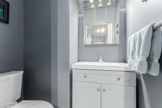 bathroom featuring toilet and vanity