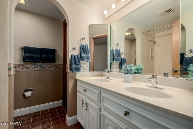bathroom with tile patterned floors, double vanity, a sink, and visible vents