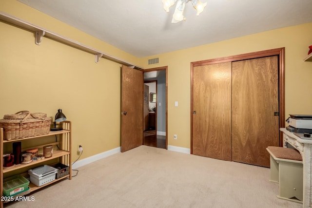 carpeted bedroom with a closet, baseboards, and visible vents