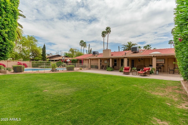 back of property with a fenced in pool, a patio, fence, and a lawn