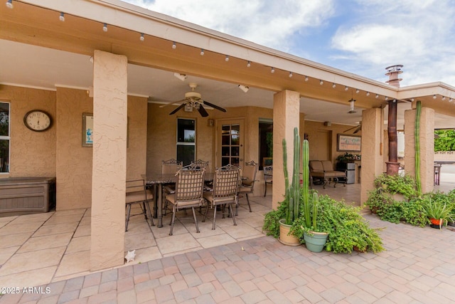 view of patio with outdoor dining area and a ceiling fan